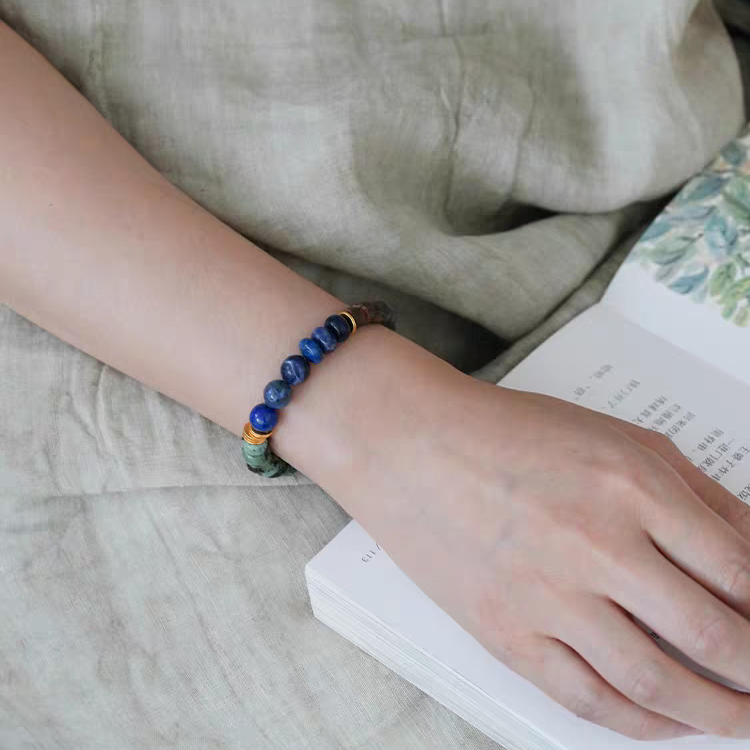 Close-up of Handmade Earth & Sky Energy Bracelet featuring Lapis Lazuli, Green Jasper, and Black Onyx beads with gold accents for added elegance.