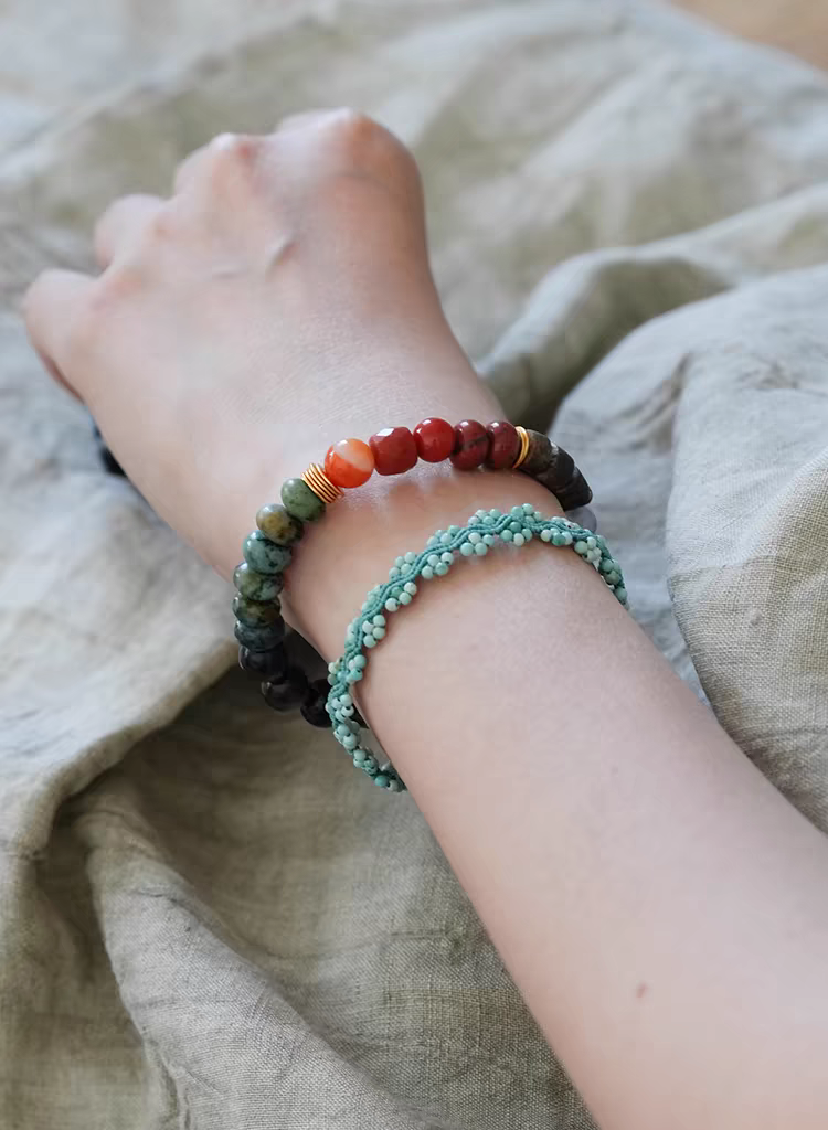 Close-up of Nirvana Lumière Handmade Earth Energy Bracelet – Black Agate, Green Jasper, and Orange Carnelian beads with gold accents, promoting grounding and emotional stability.