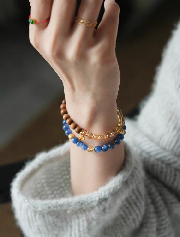 Natural amber and crystal healing bracelet resting on a wooden surface – A piece of jewelry designed for balance and wellness.