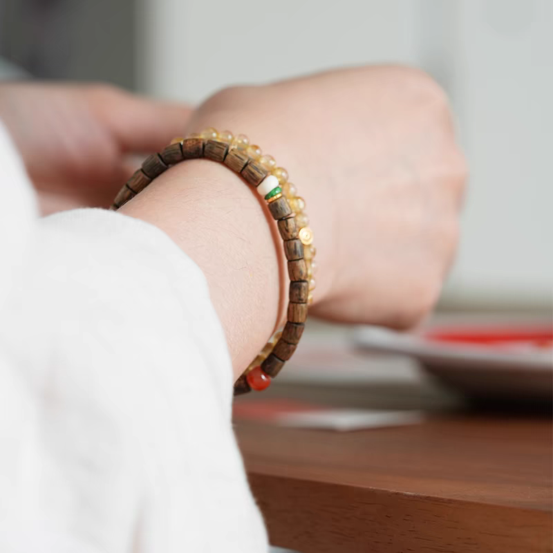 Close-up of 20-year aged agarwood beads in Qiū Shí Xù Feng Shui Bracelet, known for calming and purifying energy