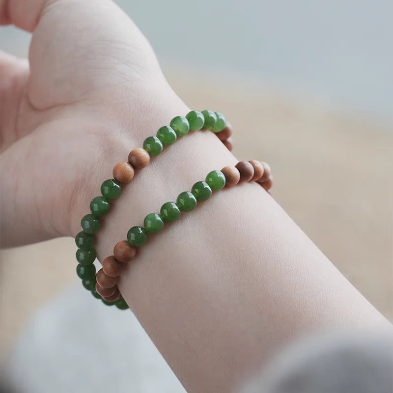 Close-up of the Luoyan natural stone bracelet, showing green jade, sandalwood, and 18k gold details