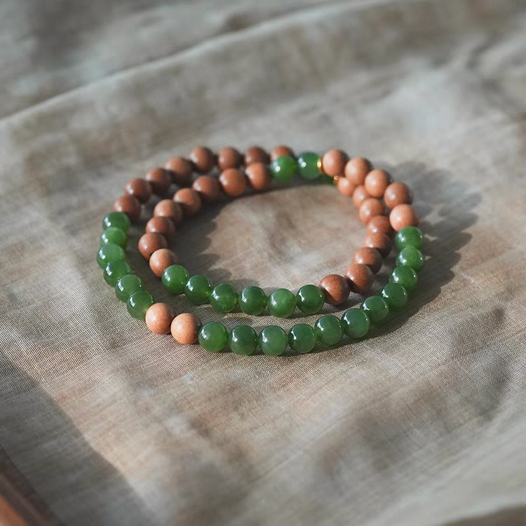 Side view of Luoyan handmade bracelet, featuring 18k gold accents and green jade stones